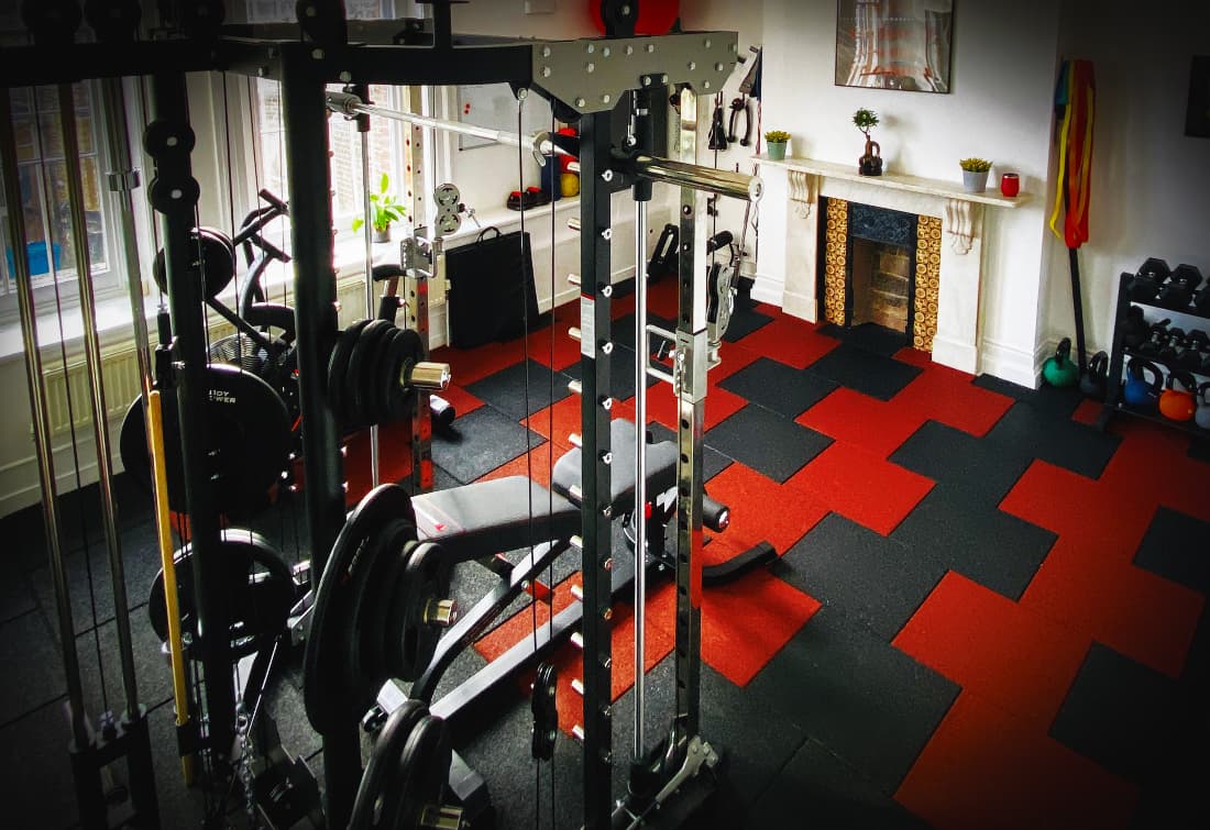 Inside the KD Personal Training private studio — power rack, smith machine and red and black gym flooring